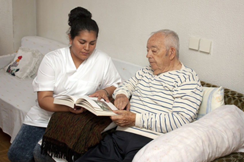 A Woman Helping an Elder Man to Read