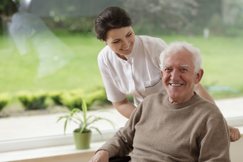 A Senior Man in a Wheelchair With a Nurse