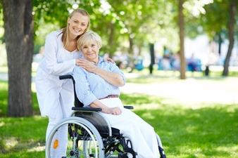 A Senior Woman in a Wheelchair With a Young Lady