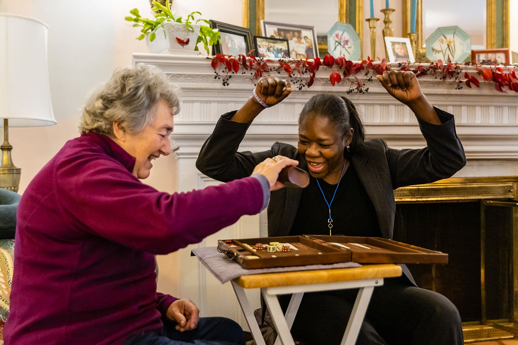 An Elderly Woman Paying a Board Game With a Young Lady