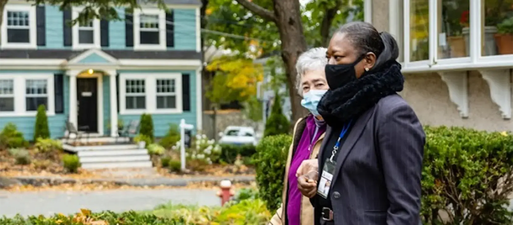 Caregiver and client walking outside with masks on