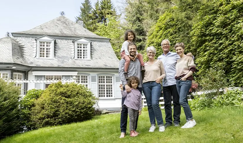 Multi-generational family stands outside their home