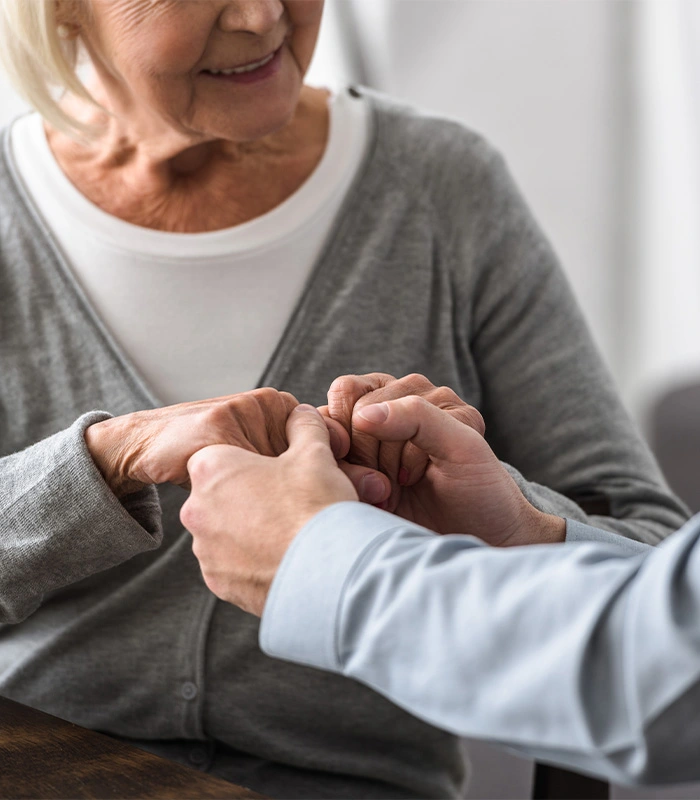 Caregiver and client holding hands