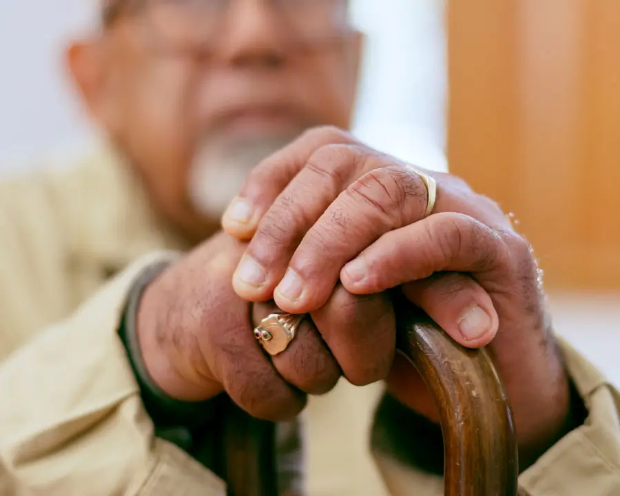 Closeup of man's hands holding a cane