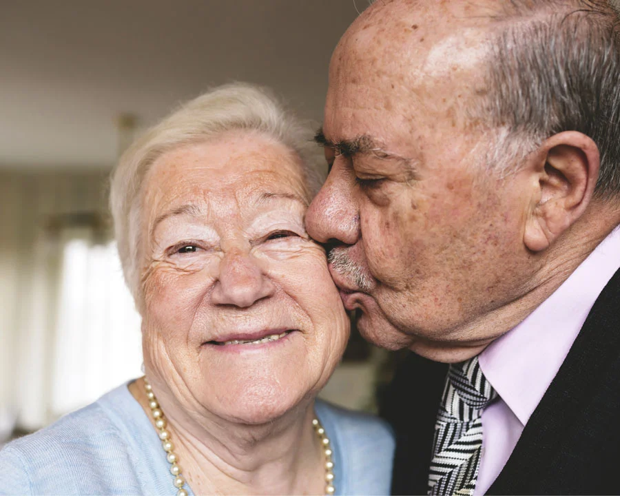 Senior man kisses his wife on the cheek