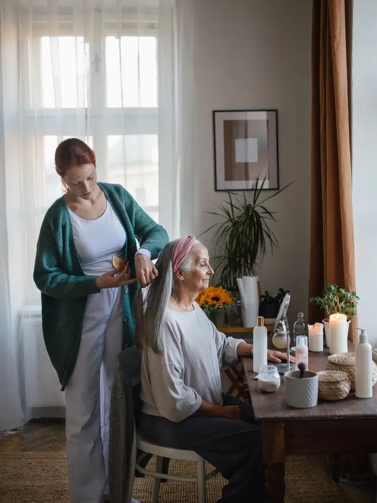 Caregiver helps senior woman do her hair