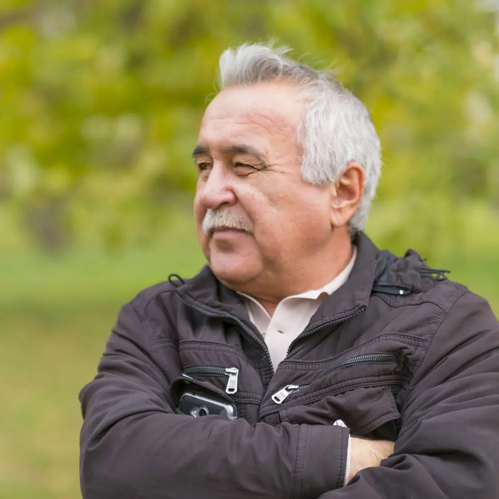 Man sitting outside with his arms folded